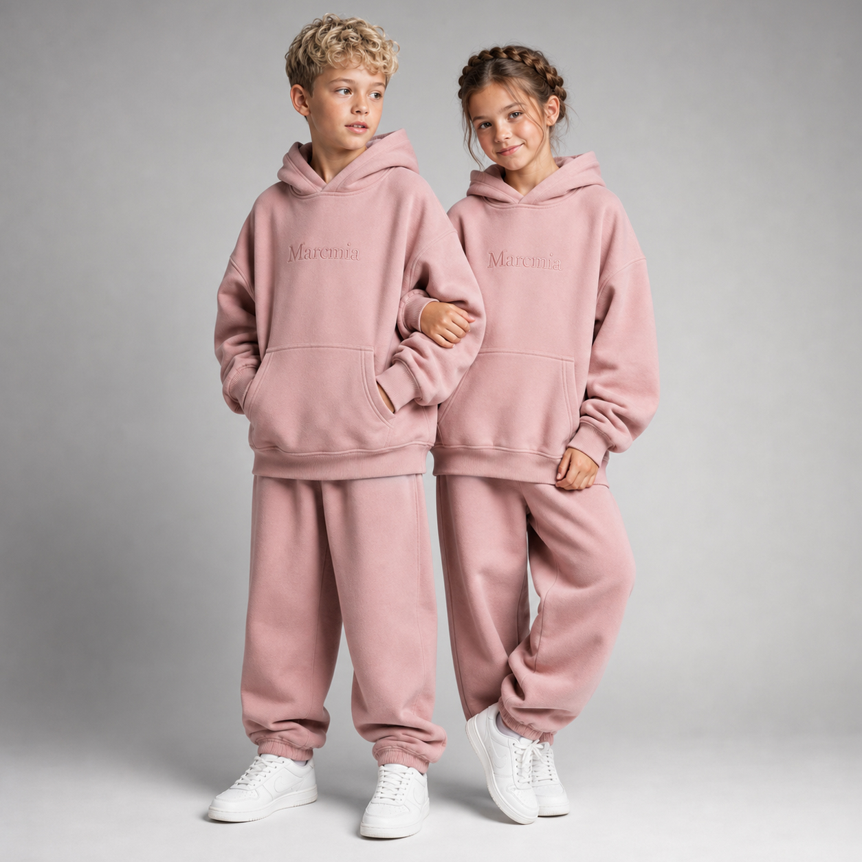 Two children wearing dusty pink Marcmia hoodie sets