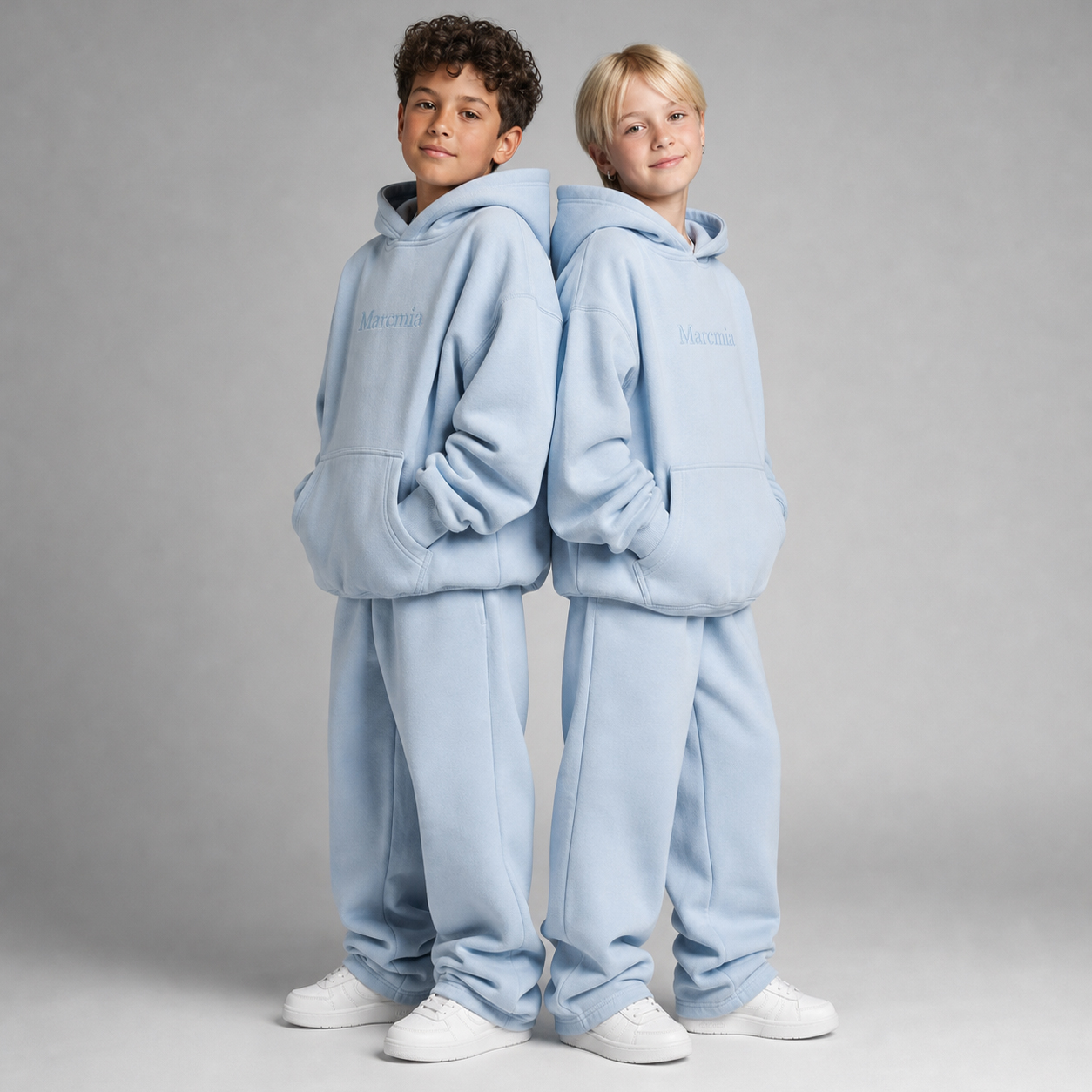 Two children wearing cloud blue Marcmia hoodie sets