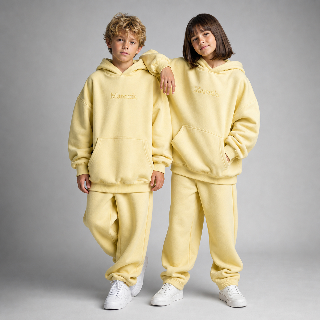Two children wearing butter yellow Marcmia hoodie sets