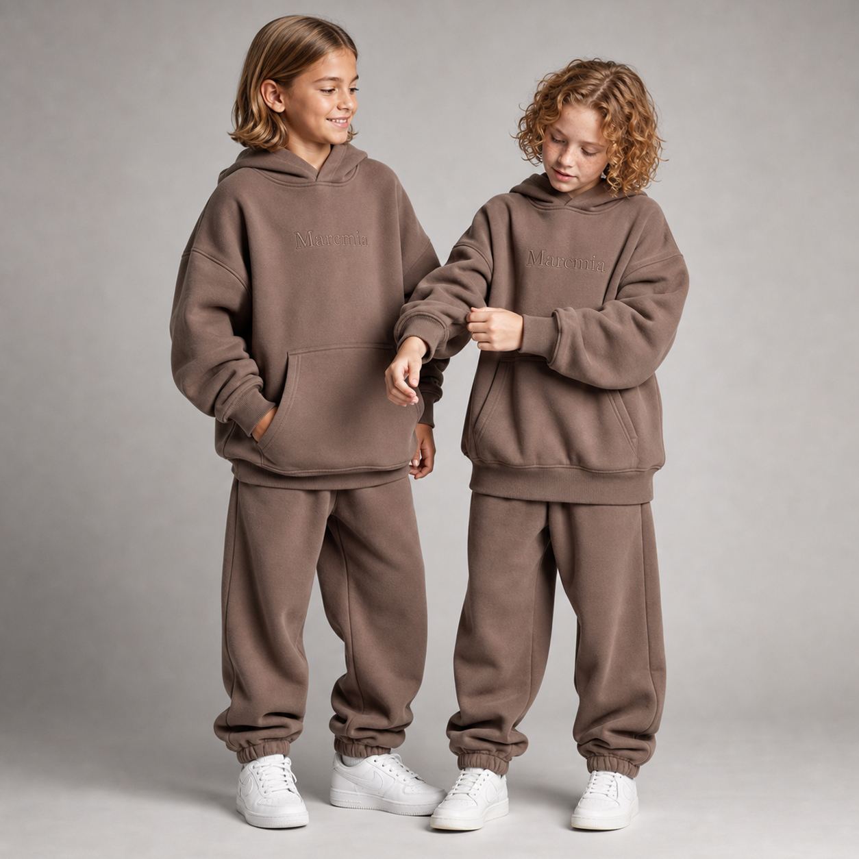Two children wearing cocoa Marcmia hoodie sets